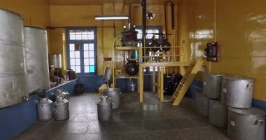 Closeup of oil extraction and distillation machines and tanks inside the factory