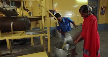 Mysore,India-June 20,2016:Closeup of workers working inside the oil extraction and distillation factory