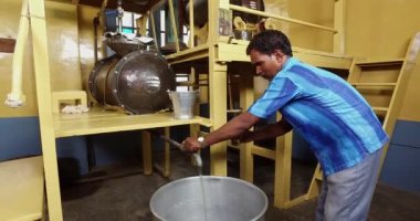 Mysore,India-June 20,2016:Closeup of an expert examining the oil quality in small glass inside the factory
