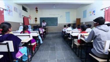 Kaiwara,Chikkaballapura,India-January 5,2017:Back view of students listening to the lecture of teacher in the classroom during class hours