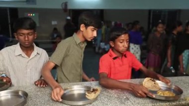 Kaiwara,Chikkaballapura,India-January 5,2017:Boys students are receiving dinner in the canteen while they wait in line at school canteen counter