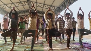 Kaiwara,Chikkaballapura,India-January 5,2017:A group of male students practicing Yoga at school outdoor auditorium during morning time