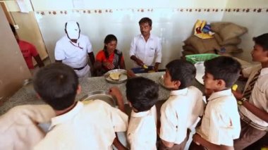 Kaiwara,Chikkaballapura,India-January 6,2017:Students are receiving meals in the canteen while waiting in line at rural school in karnataka
