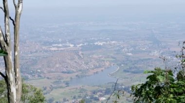 Large view of farms, lakes, and small villages from mountain's summit during summer time