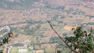 Large view of farms, lakes, and small villages from mountain's summit during summer time