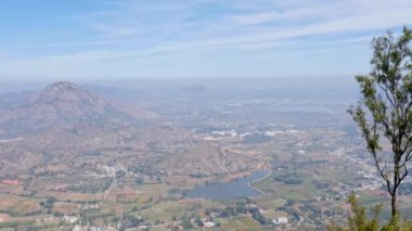 Panoramic view of farms, lakes, and small villages from mountain's summit during sunny day