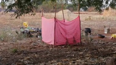 A closeup video of poor people temporary saree bathroom at indian village during summer