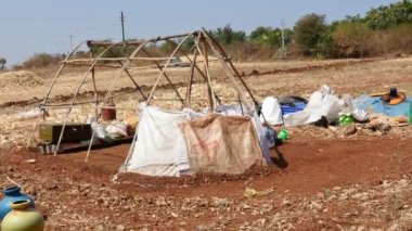 A closeup of temporary tent being built by nomadic people in the dry fields of village