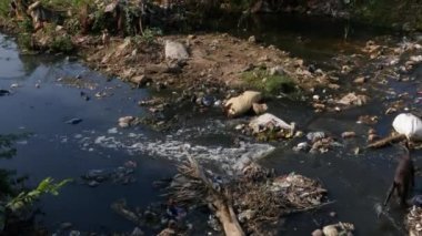 A view of dirty drainage water full of trash at an Indian village flowing during summer