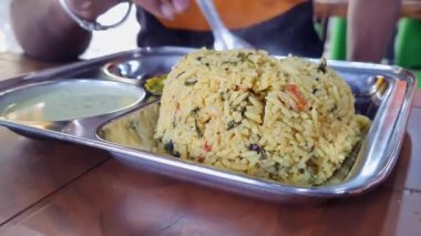 A close-up of hot methi pulao or fenugreek rice served on a plate.south indian breakfast recipe methi pulao served with coconut chutney and sambar