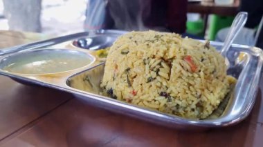 A close-up of hot methi pulao or fenugreek rice served on a plate.south indian breakfast recipe methi pulao served with coconut chutney and sambar