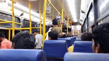 Bangalore,India-June 24,2022:A back view of passengers sitting inside the bus at night .bus waiting for passengers
