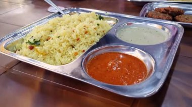 A close-up of hot figure rice or lemon rice served on a plate.south indian breakfast recipe lemon rice served with coconut chutney and sambar