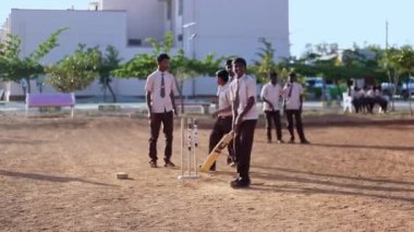 Kaiwara,Chikkaballapura,India-January 5,2017:A closeup of a boy batting while playing cricket on the playground during play time at the school campus