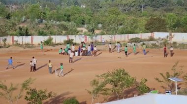 Kaiwara,Chikkaballapura,India-January 6,2017:Wide view of male students playing cricket and volleyball on the playground during the evening