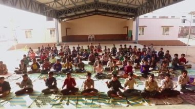 Kaiwara,Chikkaballapura,India-January 6,2017:Wide view of male students clapping after a yoga class in the auditorium during the morning