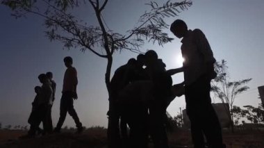 Kaiwara,Chikkaballapura,India-January 6,2017:Group of male students working together to clean up the school campus during a sunny morning