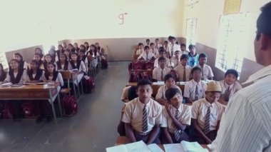 Kaiwara,Chikkaballapura,India-January 6,2017:Front view students sit on the benches while the teacher teaches in the classroom at a rural school in Karnataka