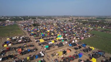 Hindu dini festivali karnikotsava sırasında tarlalarda barınan renkli çadırlar, dükkanlar ve dindarlarla dolu kalabalık bir kasaba fuarının hava görüntüsü. (Kehanet)