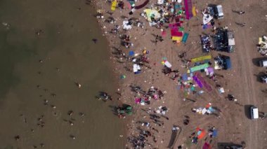 Aerial top view of the crowd bathing on the large river bank during hindu religious festival
