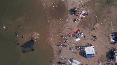 Aerial top view of the crowd bathing on the large river bank during hindu religious festival