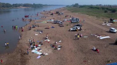 Vijayanagara,India-February 7,2023:A large crowd of people and vehicles gathered at large riverbanks during a Hindu religious festival karnikotsava(prophecy)