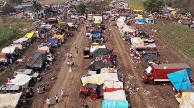 Vijayanagara,India-February 7,2023:Aerial view of crowds of devotees camped in maze fields with vehicles during a Hindu religious festival