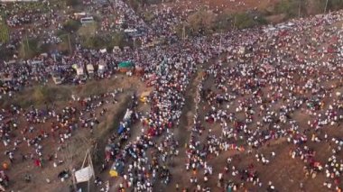 Vijayanagara,India-February 7,2023:Aerial view of large crowd of people moving on roads and farmlands during a hindu religious event karnikotsava or prophecy