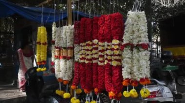 Bangalore,India-February 12,2023:Close-up of red rose and tuberose garlands for sale at a roadside local shop