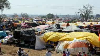 Vijayanagara,India-February 7,2023:Panoramic view of a large number of tents or shelters being set up on fields during the celebration of a Hindu religious festival