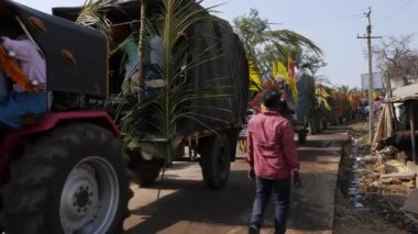 Vijayanagara,India-February 7,2023:A view of many tractors travelling in a row along a busy road during the Hindu religious festival in India