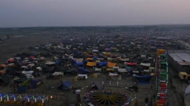 A view from the Ferris wheel a sizable Indian fair with shops and crowds sheltered during Hindu religious festival