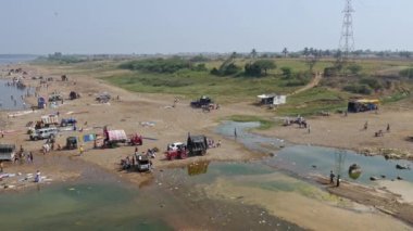 Vijayanagara,India-February 5,2023:Panoramic view of people bathing in the large river's water during sunny day