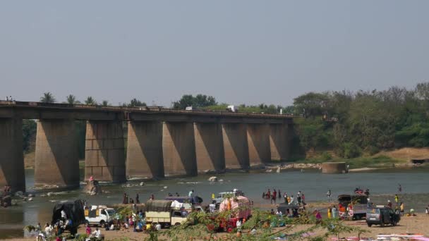 インド ヴィジャヤナガラ2023年2月5日 宗教行事中に川岸に車両や橋の上を移動する車両を持つ人々の映像 — ストック動画