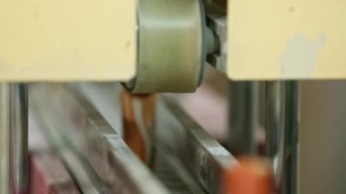 A closeup of talcum powder bottles moving on a conveyor belt for the sealing during production