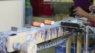 A closeup of talcum powder bottles moving on a conveyor belt for the sealing during production