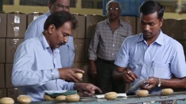 Bangalore, Hindistan-Nisan 6 2016: Yapım sırasında sabun fabrikasında yarı otomatik sabun ambalajı kullanan işçilerin kapatılması