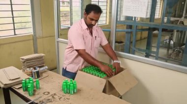 Bangalore, Hindistan-Nisan 6 2016: Hindistan cevizi şişelerinin hızlandırılmış videosu bir kutuya monte edildi ve petrol üretim ünitesinde çalışan bir işçi tarafından kaydedildi