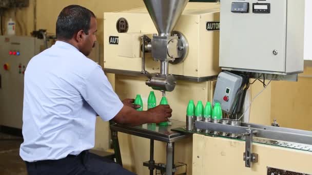 インド バンガロール2016年4月6日 工場の半自動充填機の労働者によって瓶に充填されているココナッツオイルの閉鎖 — ストック動画