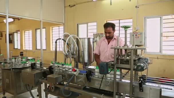 インド バンガロール2016年4月6日 工場での生産中に密封するために労働者がココナッツオイルボトルをキャップしたビデオ — ストック動画