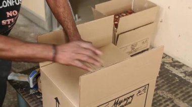Bangalore, Hindistan-Nisan 6 2016: Talk pudrası şişelerinin görüntüsü bir kutuda toplandı ve fabrikada çalışan bir işçi tarafından bantlandı
