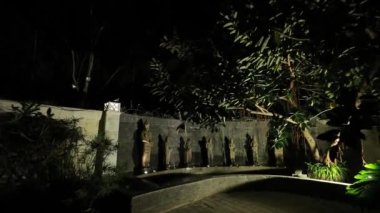 Kadın heykellerinin bahçeye çeşme döktüğü bir gece manzarası. Düğün dekorasyonu konsepti.