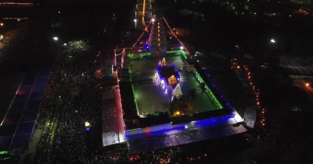 ヒンズー教の宗教行事を祝うために集まった人々と光の装飾が施された寺院の空中夜景 — ストック動画