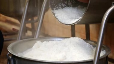 Pişmiş pirincin fabrikanın içindeki büyük çelik bir kaba dökülmesi.