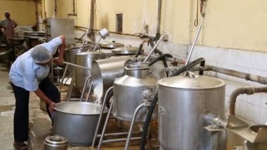 Bangalore, Hindistan-Nisan 7 2016: Bir aşçının veya işçinin fabrika mutfağında büyük bir çelik kaba pilav dökmesi görüntüsü