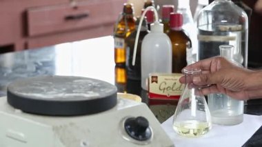 Bangalore, Hindistan-Nisan 7 2016: Erlenmeyer matarasını sabun ve kimyasallarla dolu bir tabağa ya da laboratuvarın içindeki bir fırına yerleştiren bir işçinin görüntüsü