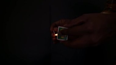 Bir adamın karanlık yaratıcı kavramlarla kibrit yaktığı yakın çekim videosu. Eğitici.