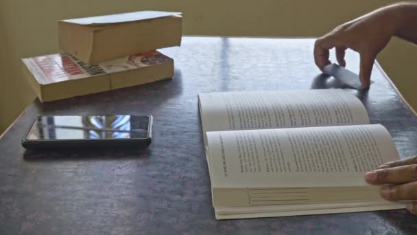後で続けるために読書を終えた後 本の中にノートカードを置く男の閉鎖 — ストック動画