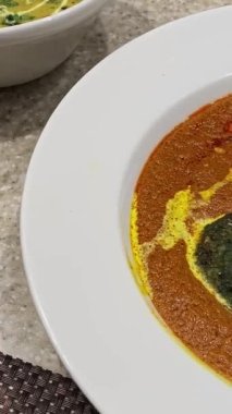 Bir kase içinde servis edilen baharatlı kırmızı körili özel sebze pirzolası.