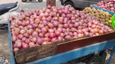 Yol kenarında satılan el arabalarında bir sürü organik kırmızı soğan var. Sebze. Satılık taze soğanlar.